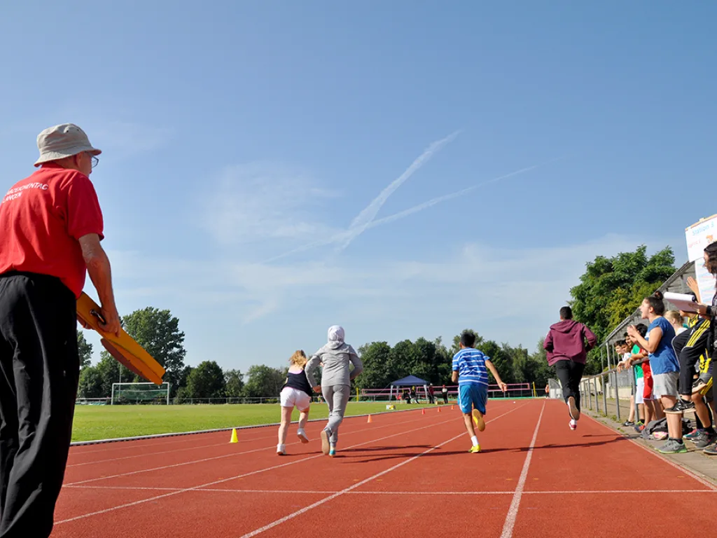 Läufer beim Zieleinlauf auf der Bahn.